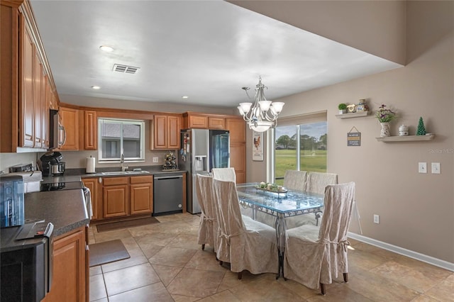 2710 Alabaster Ave, Orlando, FL 32833 - kitchen with stainless steel appliances, a sink, dark countertops, visible vents, and an inviting chandelier