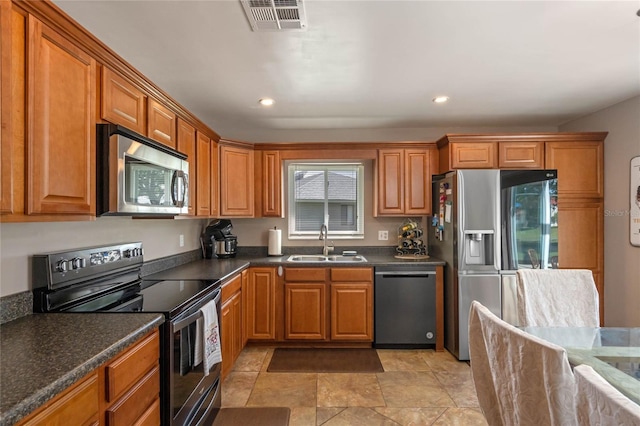 2710 Alabaster Ave, Orlando, FL 32833 - kitchen with brown cabinetry, appliances with stainless steel finishes, a sink, and visible vents
