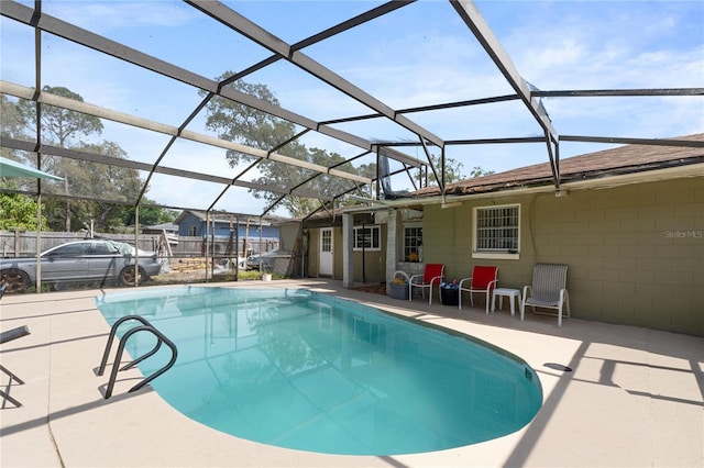 outdoor pool with a patio area and glass enclosure