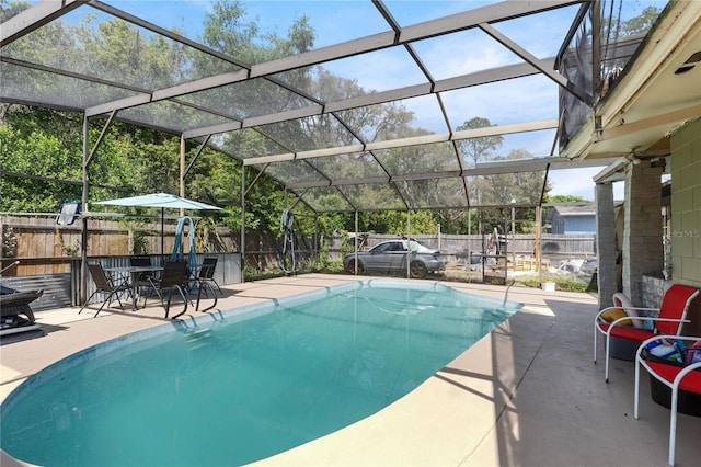 view of swimming pool with a fenced backyard, a patio area, a fenced in pool, and glass enclosure