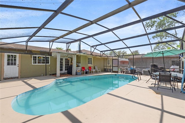 pool with glass enclosure, a patio area, and french doors