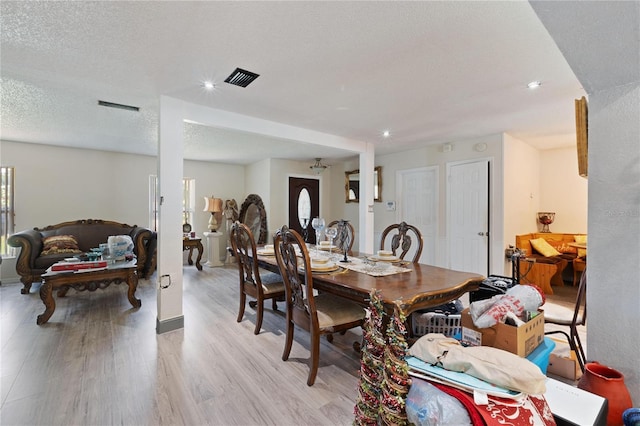 dining space with a textured ceiling, visible vents, recessed lighting, and light wood-style floors