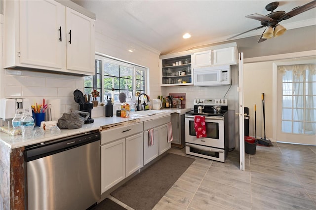 kitchen featuring open shelves, a sink, decorative backsplash, light countertops, and appliances with stainless steel finishes