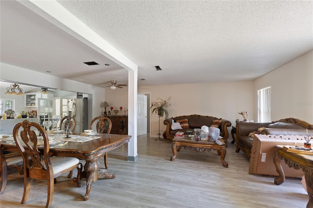 dining area featuring plenty of natural light, a ceiling fan, a textured ceiling, and light wood-style flooring