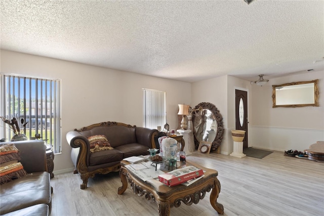 living room with a textured ceiling and light wood-type flooring