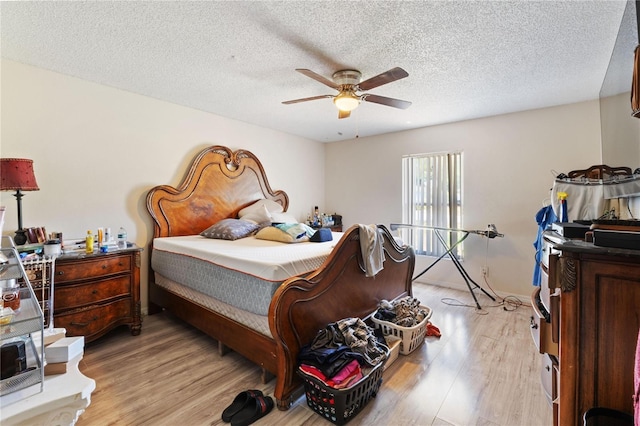 bedroom featuring light wood-style flooring, a textured ceiling, and a ceiling fan