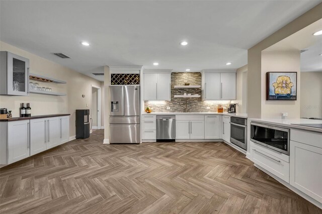 1003 Shore Dr, Kissimmee, FL 34744 - kitchen featuring backsplash, open shelves, appliances with stainless steel finishes, and visible vents