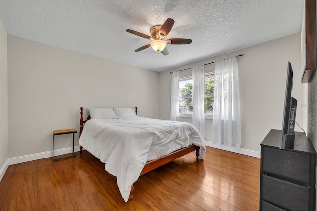 1003 Shore Dr, Kissimmee, FL 34744 - bedroom featuring baseboards, ceiling fan, a textured ceiling, and wood finished floors
