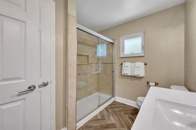 1003 Shore Dr, Kissimmee, FL 34744 - bathroom featuring toilet, baseboards, a shower stall, and a sink