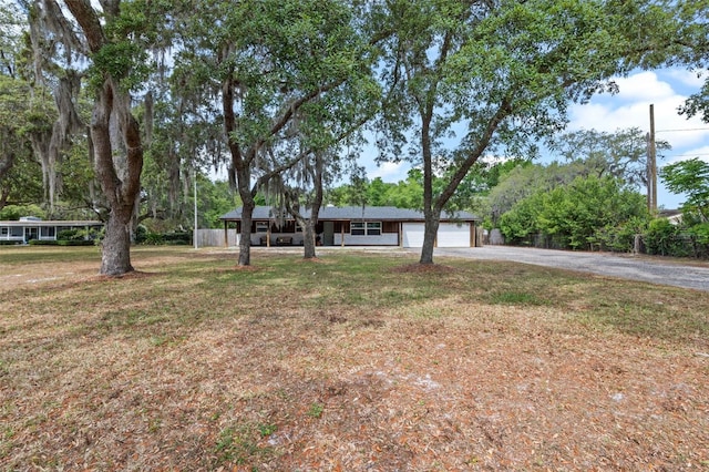 single story home with driveway, a garage, and a front yard