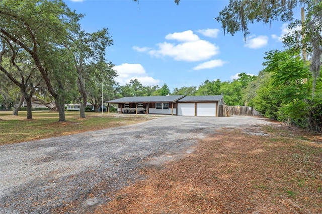 single story home featuring a garage, driveway, and fence