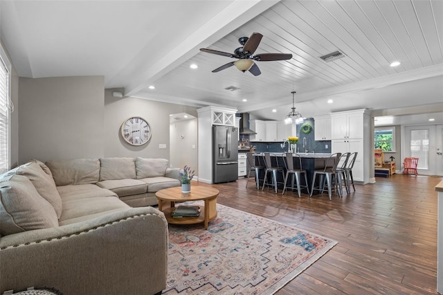 living area featuring beam ceiling, dark wood-style flooring, visible vents, recessed lighting, and a ceiling fan