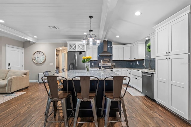 kitchen featuring wall chimney exhaust hood, appliances with stainless steel finishes, dark wood-style flooring, and visible vents