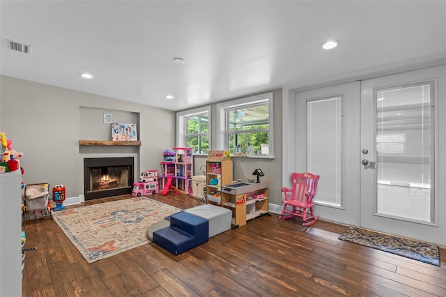 playroom with recessed lighting, visible vents, wood-type flooring, baseboards, and a lit fireplace