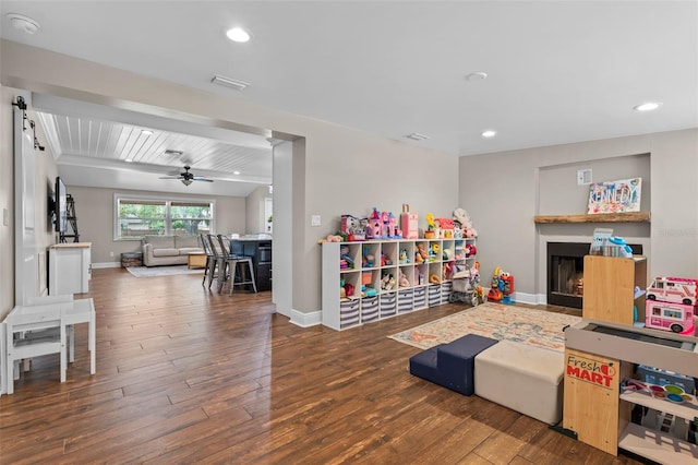 recreation room featuring wood finished floors, baseboards, and ceiling fan