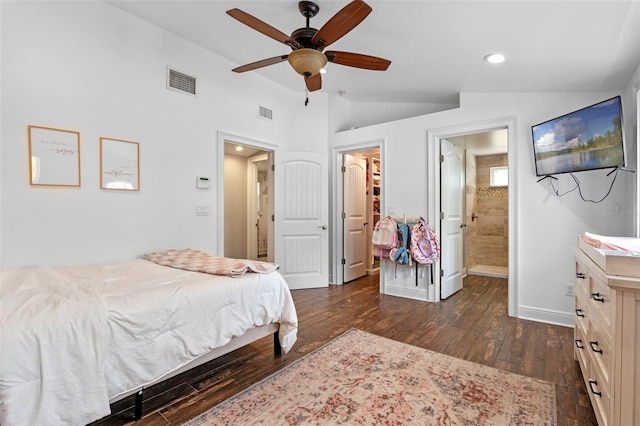 bedroom featuring dark wood finished floors, a spacious closet, vaulted ceiling, visible vents, and baseboards