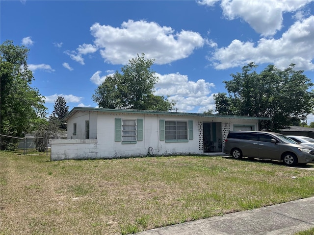 single story home featuring a front lawn and concrete block siding