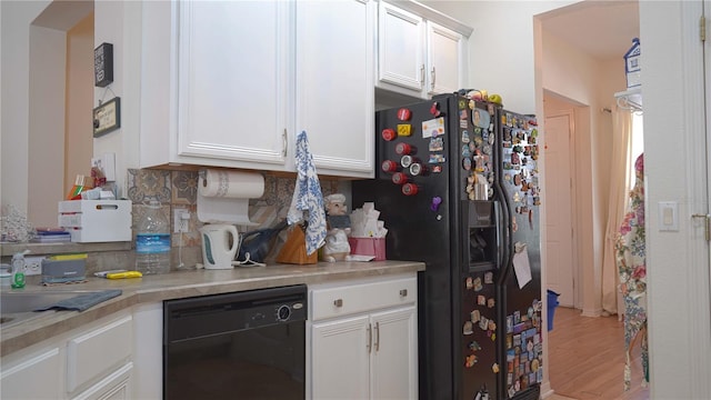7415 Devereaux St, Reunion, FL 34747 - kitchen with black appliances, white cabinets, light countertops, light wood-type flooring, and backsplash