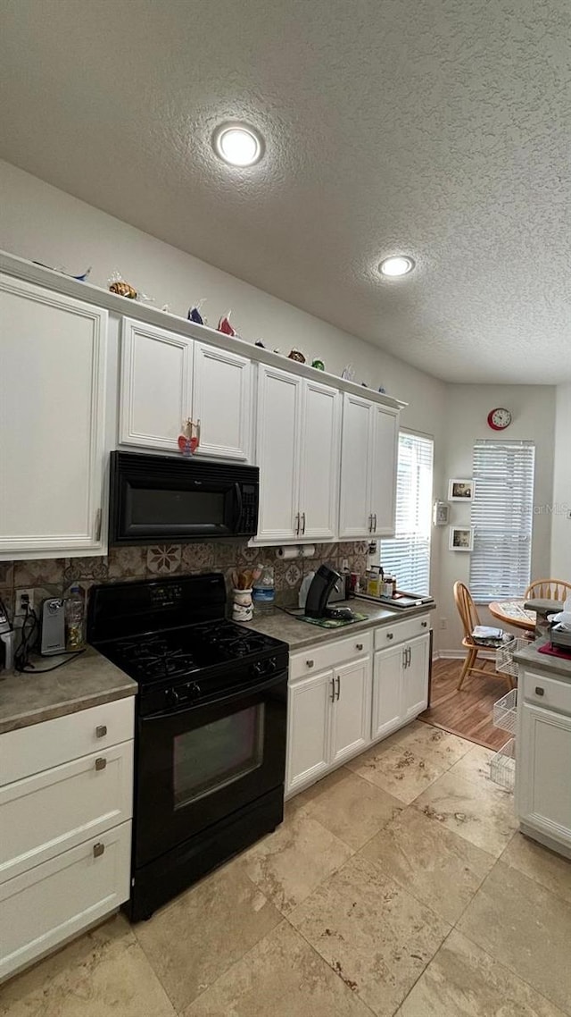 7415 Devereaux St, Reunion, FL 34747 - kitchen with black appliances, a textured ceiling, tasteful backsplash, and white cabinets