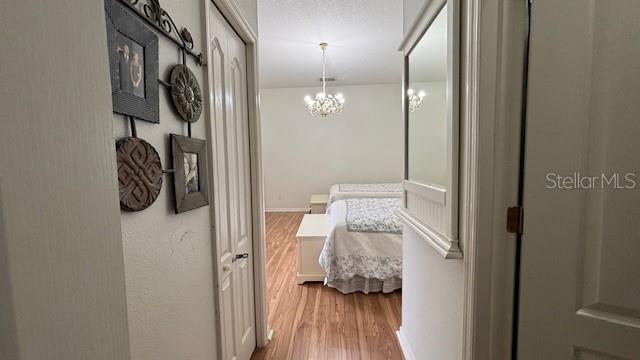 7415 Devereaux St, Reunion, FL 34747 - hallway featuring wood finished floors and a chandelier