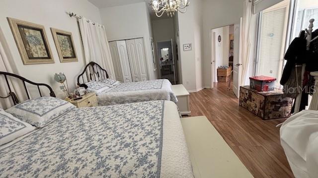7415 Devereaux St, Reunion, FL 34747 - bedroom featuring a chandelier, wood finished floors, multiple windows, and a closet