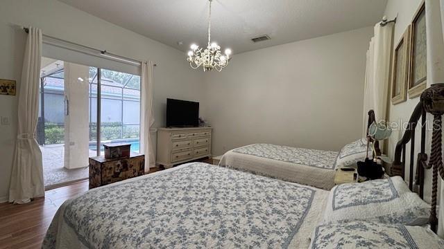 7415 Devereaux St, Reunion, FL 34747 - bedroom with access to outside, wood finished floors, and a chandelier