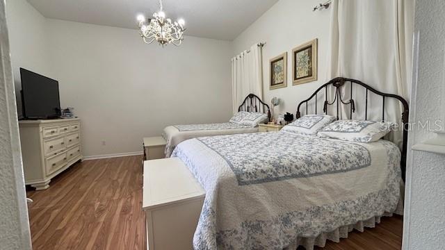 7415 Devereaux St, Reunion, FL 34747 - bedroom featuring wood finished floors and a chandelier