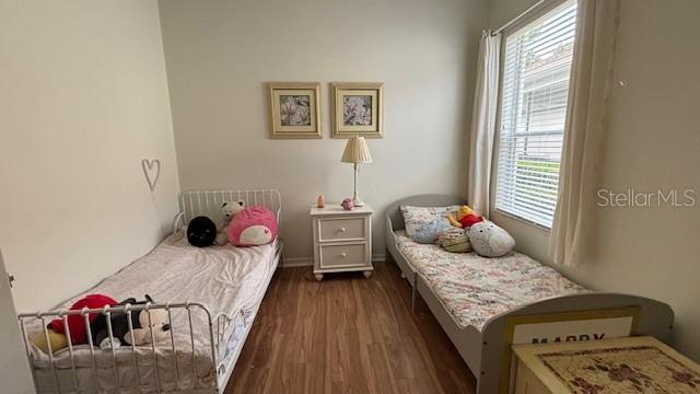7415 Devereaux St, Reunion, FL 34747 - bedroom featuring wood finished floors and multiple windows