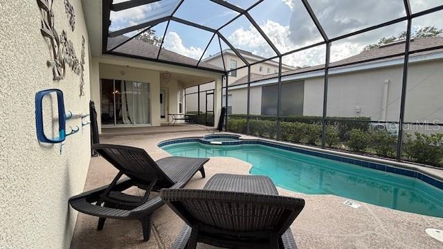 7415 Devereaux St, Reunion, FL 34747 - view of pool with a patio area, glass enclosure, and a pool with connected hot tub