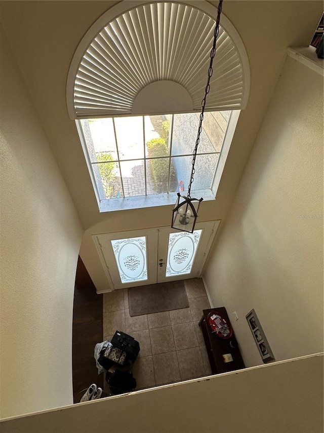 tiled entrance foyer with a towering ceiling
