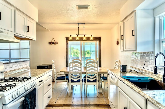 3328 Fox Rdg, Winter Haven, FL 33884 - kitchen with white appliances, backsplash, a textured ceiling, and white cabinetry