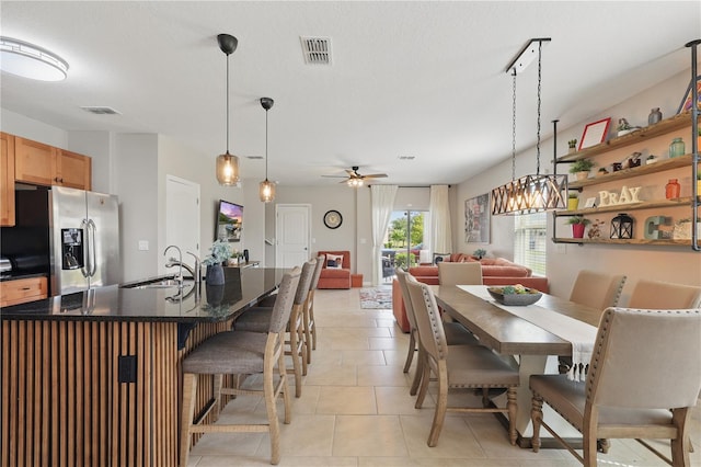dining room with a ceiling fan and light tile patterned floors