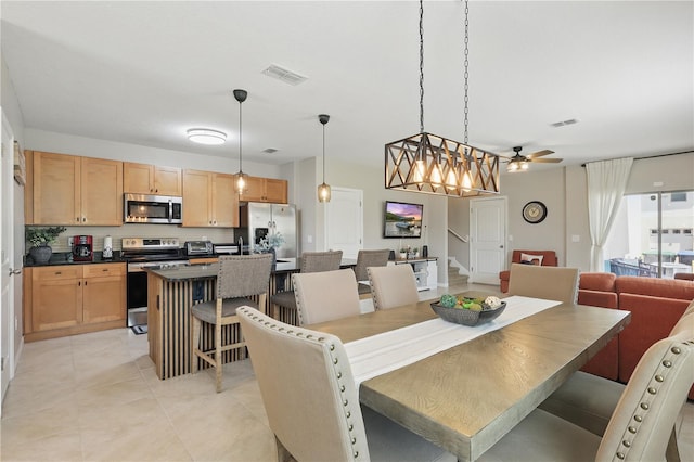 dining room with light tile patterned flooring, ceiling fan, and stairs