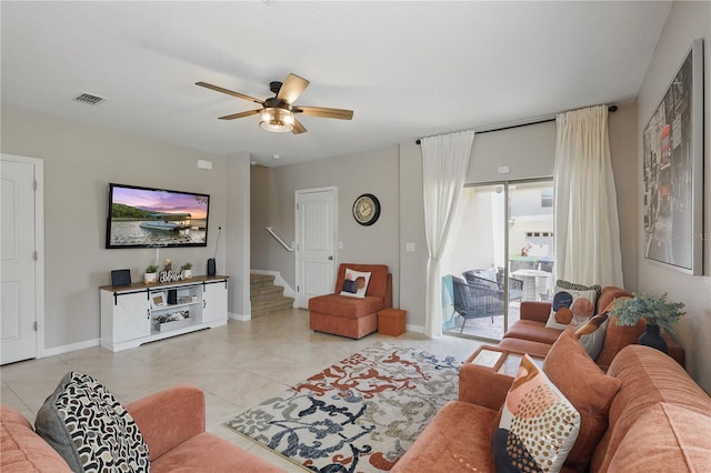 living area with stairs, ceiling fan, baseboards, and light tile patterned floors