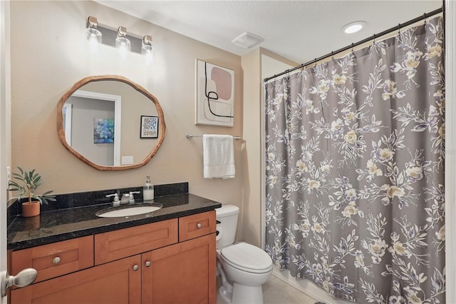bathroom featuring toilet, vanity, and a shower with curtain