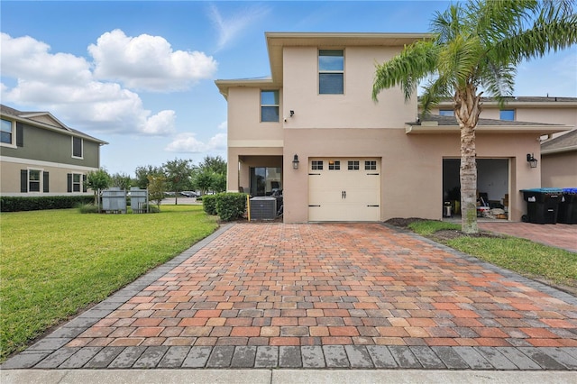 view of front of house featuring stucco siding, central AC, decorative driveway, a front lawn, and a garage