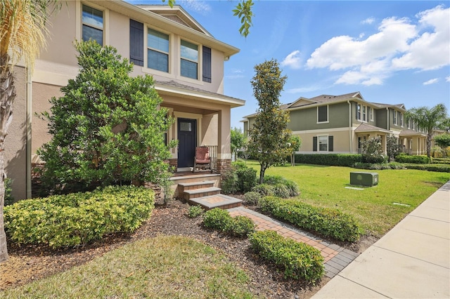 view of front of property featuring stucco siding, covered porch, and a front lawn