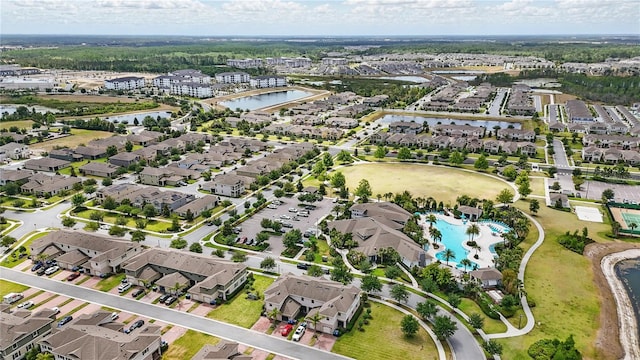 aerial overview of property's location featuring a large body of water, nearby suburban area, and a pool
