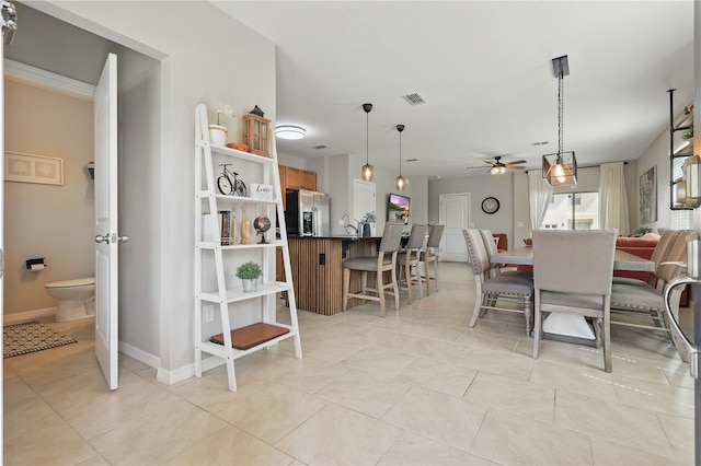 dining area featuring a ceiling fan, light tile patterned floors, and baseboards