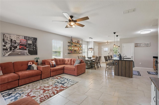 living area featuring a ceiling fan and light tile patterned floors