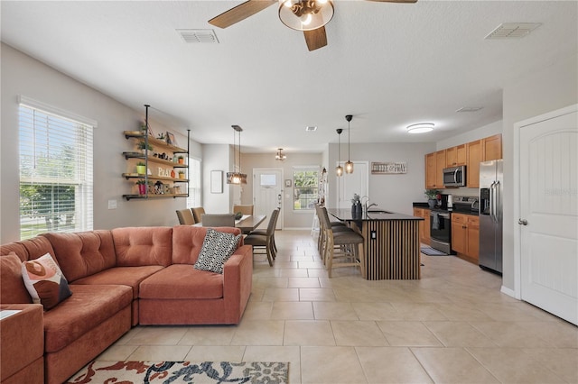 living room with ceiling fan and light tile patterned floors