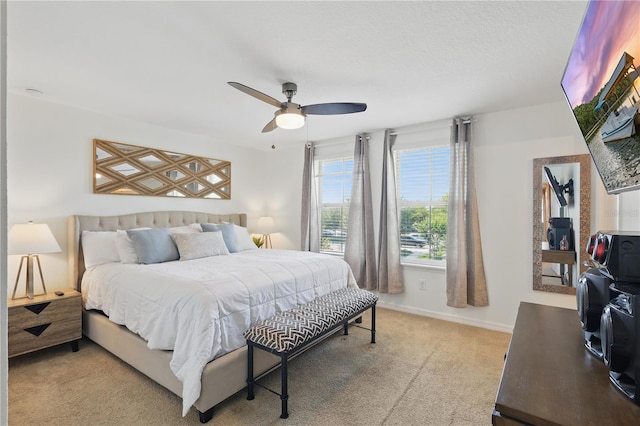 bedroom featuring light colored carpet, ceiling fan, and baseboards