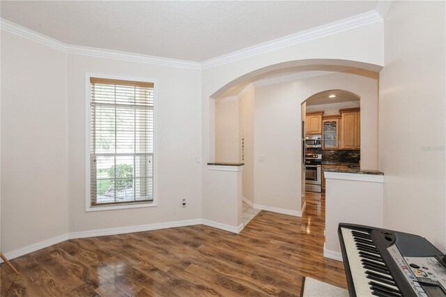 14208 Morning Frost Dr, Orlando, FL 32828 - interior space with ornamental molding, baseboards, arched walkways, and wood finished floors