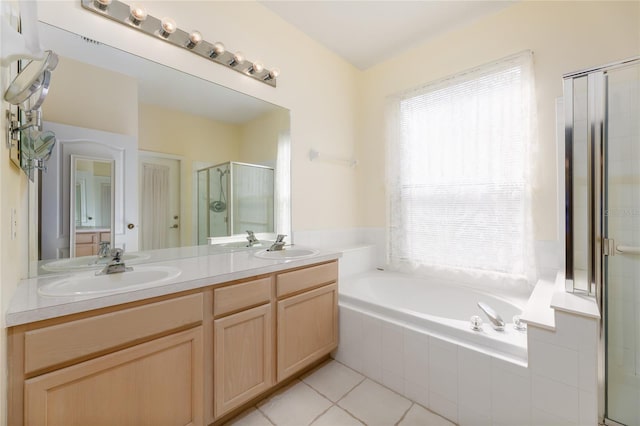 bathroom featuring tile patterned floors, a sink, double vanity, a stall shower, and a garden tub