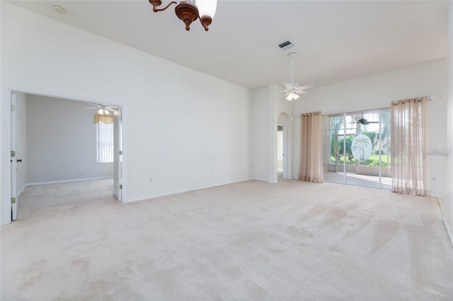 unfurnished room with arched walkways, baseboards, visible vents, light colored carpet, and ceiling fan with notable chandelier