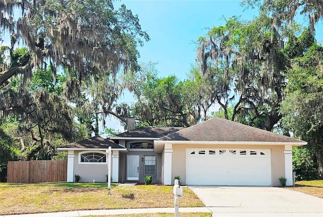 513 Rachael Ct, Oviedo, FL 32765 - view of front of property featuring fence, an attached garage, driveway, stucco siding, and a front lawn