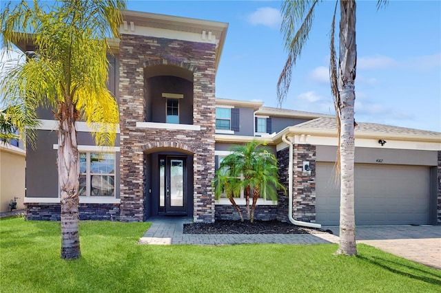 4002 Scarlet Branch Rd, Orlando, FL 32824 - view of front facade with driveway, a front yard, a garage, stone siding, and stucco siding