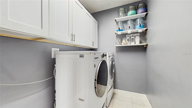4002 Scarlet Branch Rd, Orlando, FL 32824 - clothes washing area featuring light tile patterned floors, baseboards, cabinet space, and washer and dryer