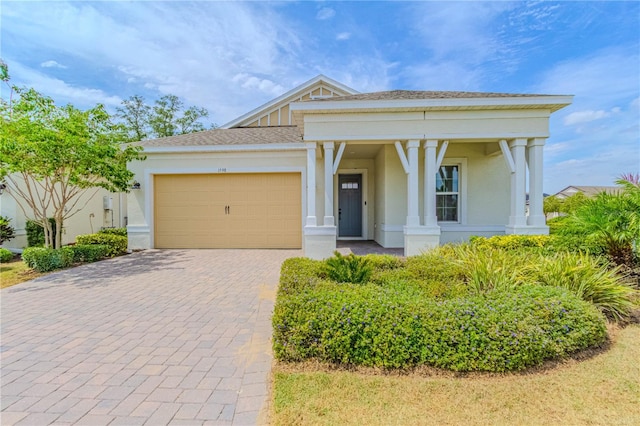 view of front of home with a garage, stucco siding, and decorative driveway