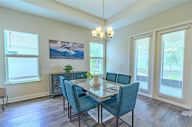 dining space with baseboards, wood finished floors, and a chandelier